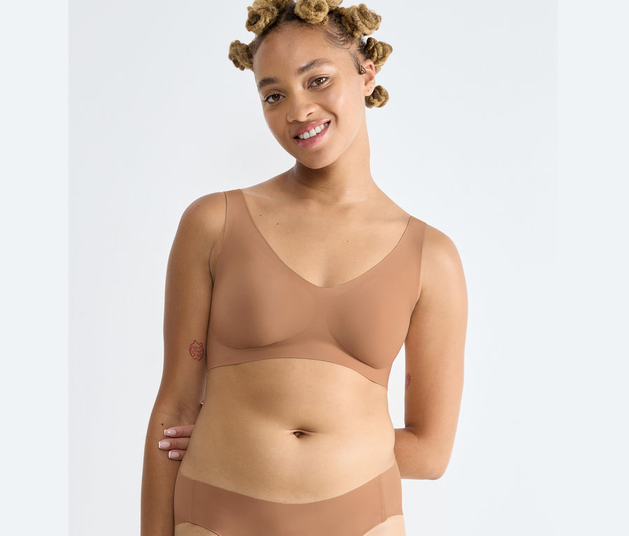 Frau trägt ein sloggi ZERO Feel 2.0 Bralette in Nostalgic Brown und passende Unterwäsche.
