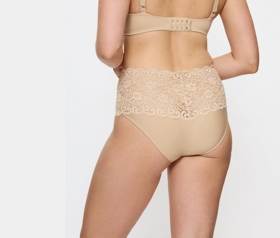 Rückansicht einer Frau, die beigefarbene Spitzen-Taillenhöschen und einen BH trägt.