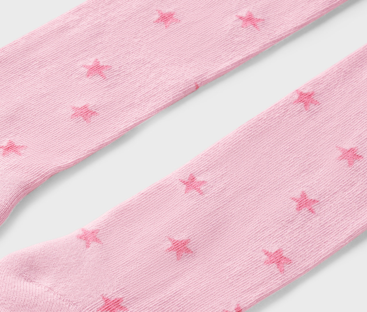 Detailaufnahme von rosa Kniestrümpfen mit Sternen.