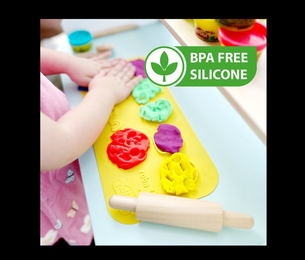 Kind spielt mit roba x Play-Doh Knet-Spielset 2 Knete auf gelber Unterlage.
