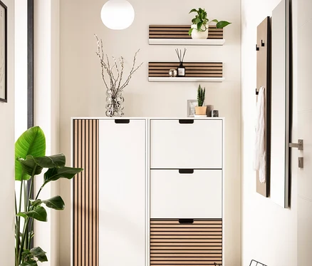 Eingangsbereich mit weißem Schuhschrank mit Holzlamellen, Regalen und Spiegel.
