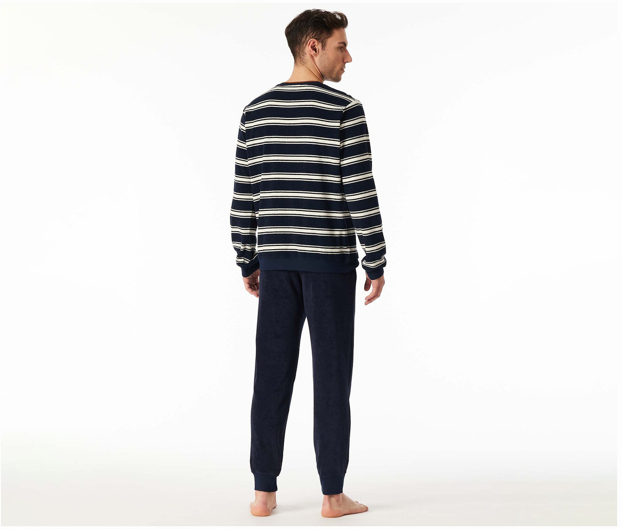 Mann von hinten in einem gestreiften SCHIESSER Frottee-Pyjama-Set mit dunkelblauer Hose und gestreiftem Oberteil.