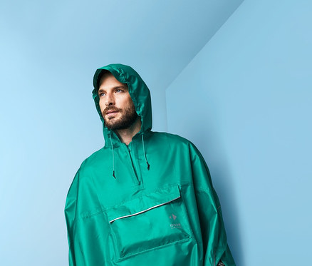 Mann trägt einen grünen Unisex-Regenponcho.