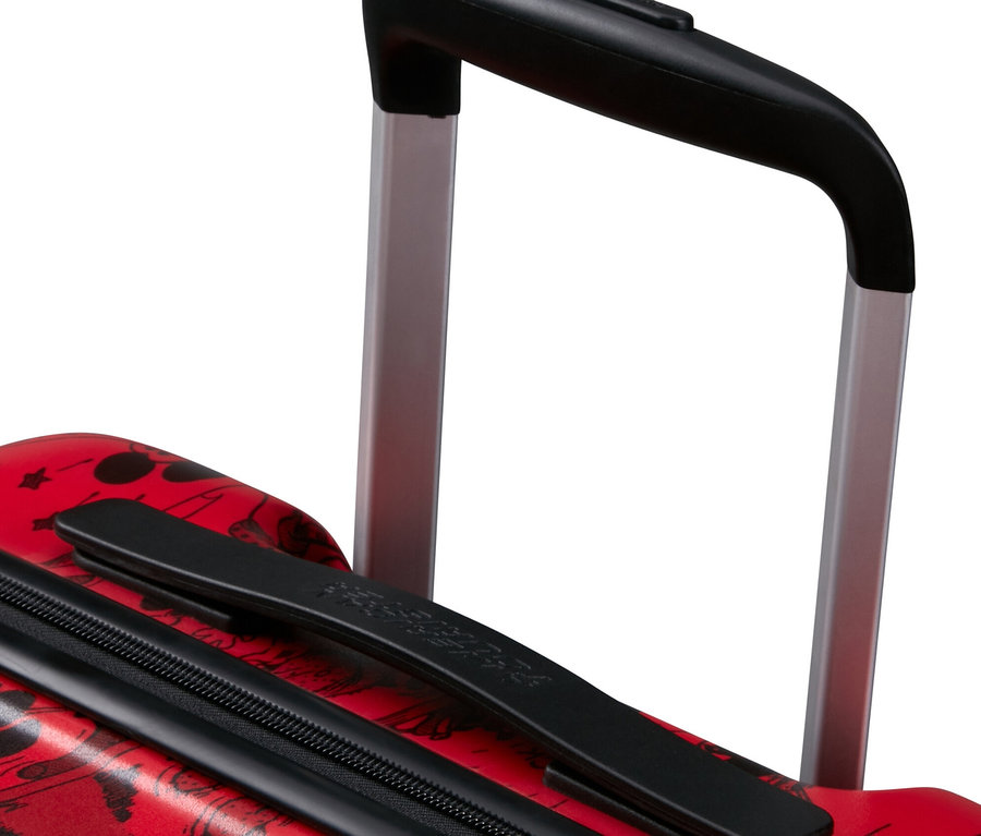 Nahaufnahme eines roten American Tourister Wavebreaker »Mickey Mouse« Koffers mit schwarzen Details und Comic-Muster.