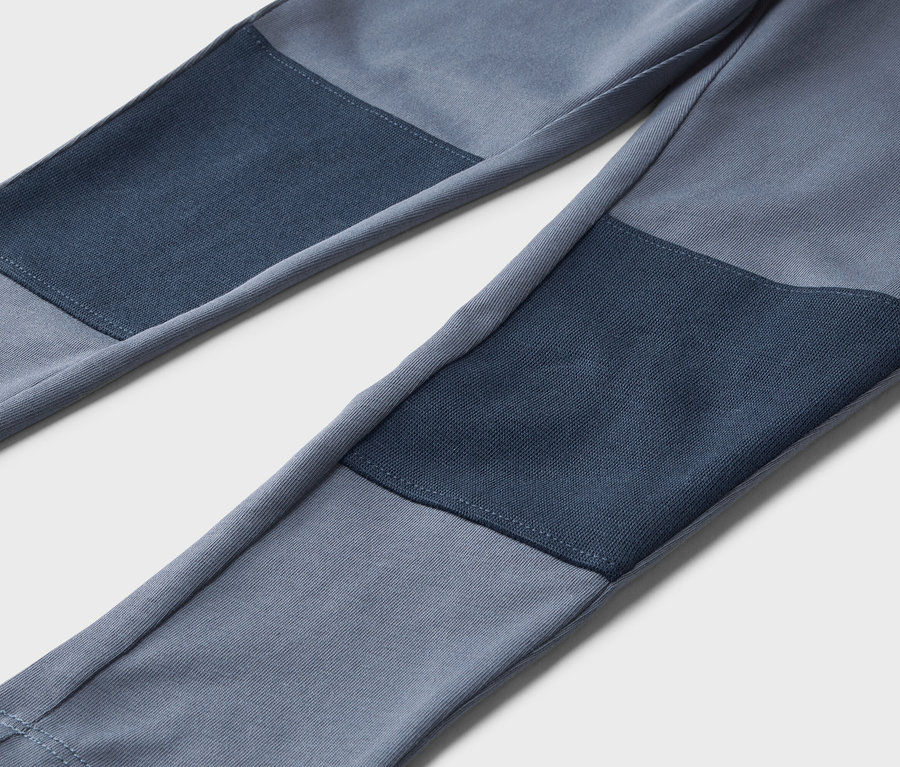 Nahaufnahme von blauen Hosen mit dunkleren blauen Flicken an den Knien.