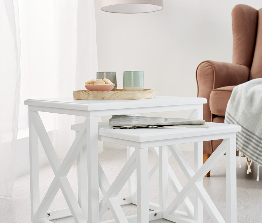 Zwei weiße Beistelltische, einer unter dem anderen.