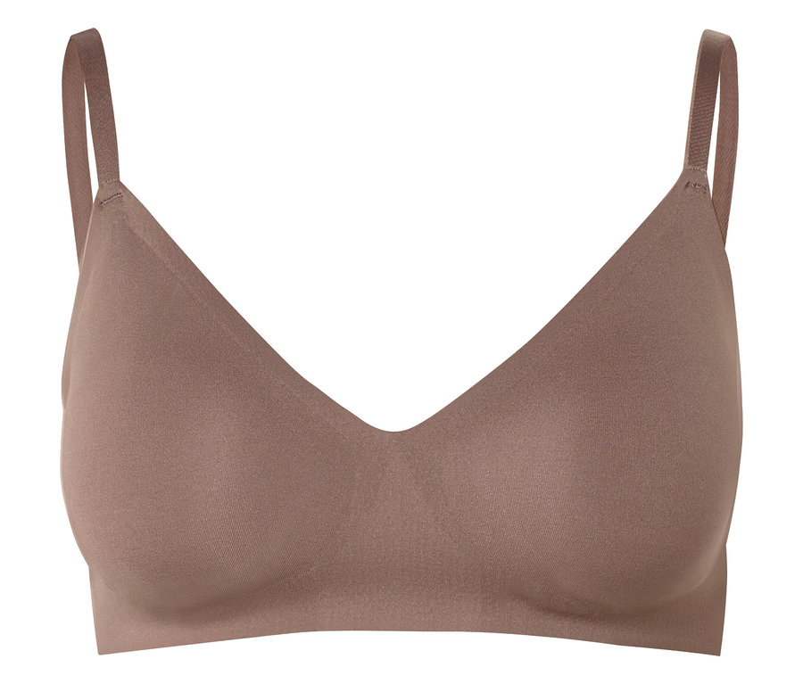 Ein hautfarbener BH mit V-Ausschnitt und dünnen Trägern vor einem weißen Hintergrund.