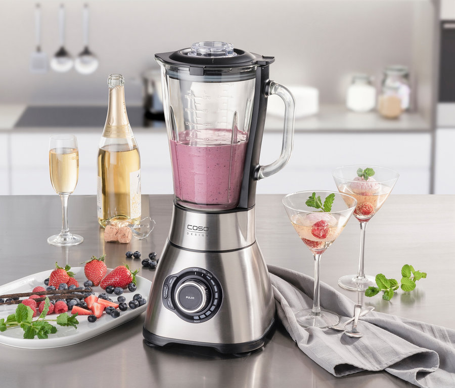 Ein Standmixer B 1800 PowerBlender steht auf einer Küchentheke, umgeben von Erdbeeren, Blaubeeren und Getränken.