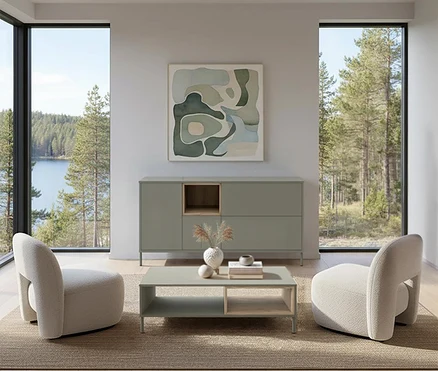 Wohnzimmer mit salbeigrünem »Hygge« Sideboard und Couchtisch. Zwei Sessel stehen auf einem Teppich vor dem Fenster mit Seeblick.