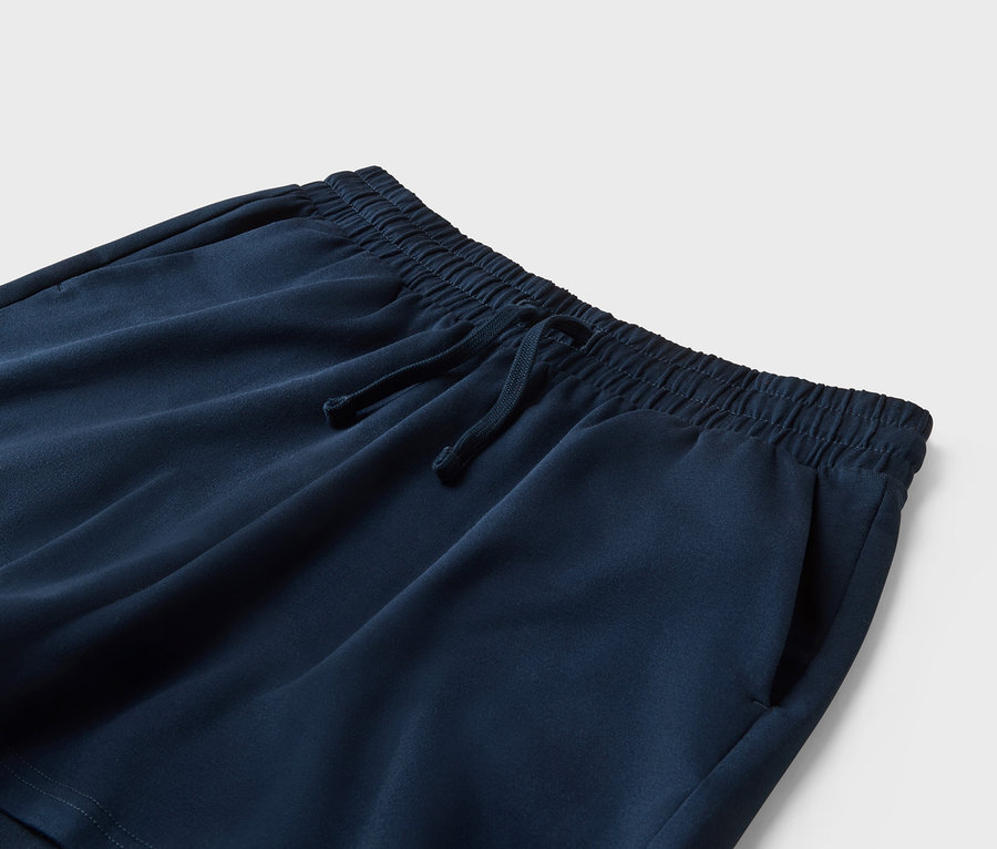 Nahaufnahme einer marineblauen Shorts mit Kordelzug und Taschen.
