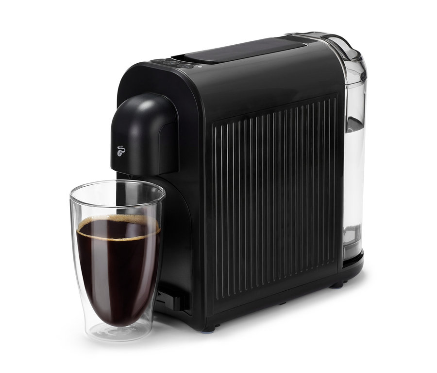 Eine schwarze Cafissimo now black Kaffeemaschine neben einem Glas mit Kaffee.