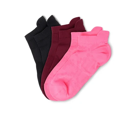 Drei Socken in Schwarz, Dunkelrot und Pink, aufgefächert auf weißem Hintergrund. Die pinke Socke hat ein dezentes Muster.
