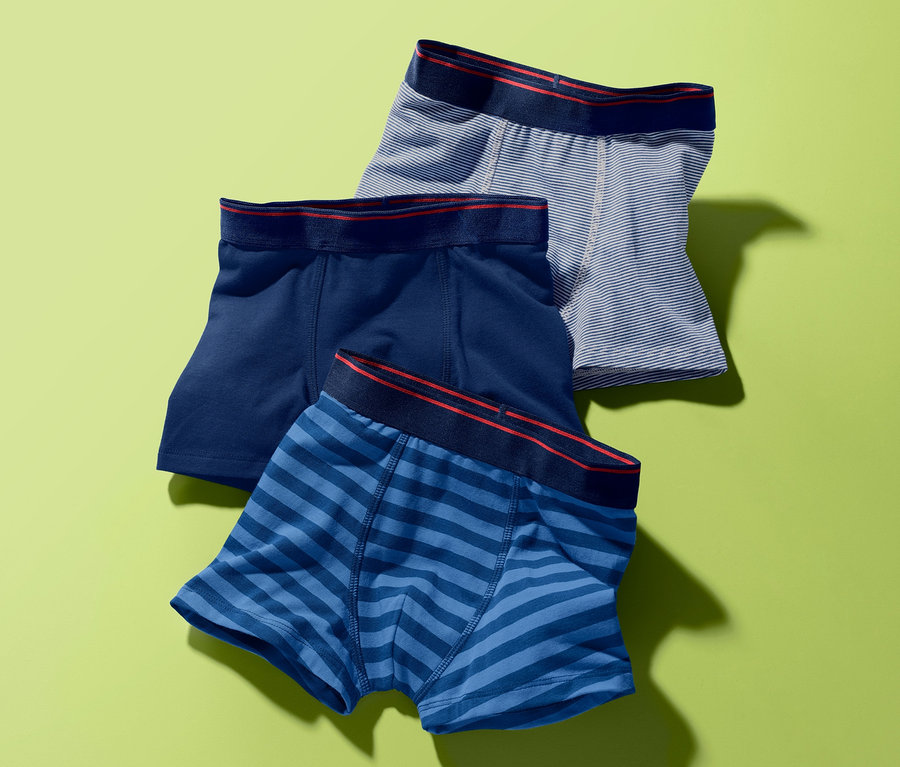 Drei Slipboxer auf grünem Hintergrund. Eine dunkelblau, eine blau gestreift und eine grau gestreift.