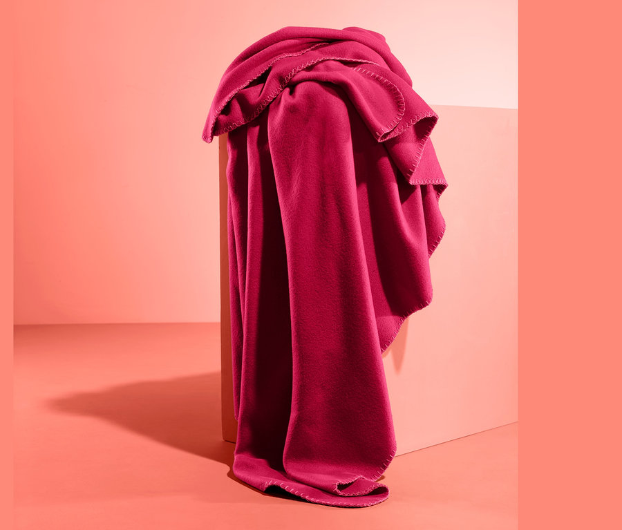 Eine Fleece-Kuscheldecke ist über eine Kante eines Objekts im Studio drapiert.