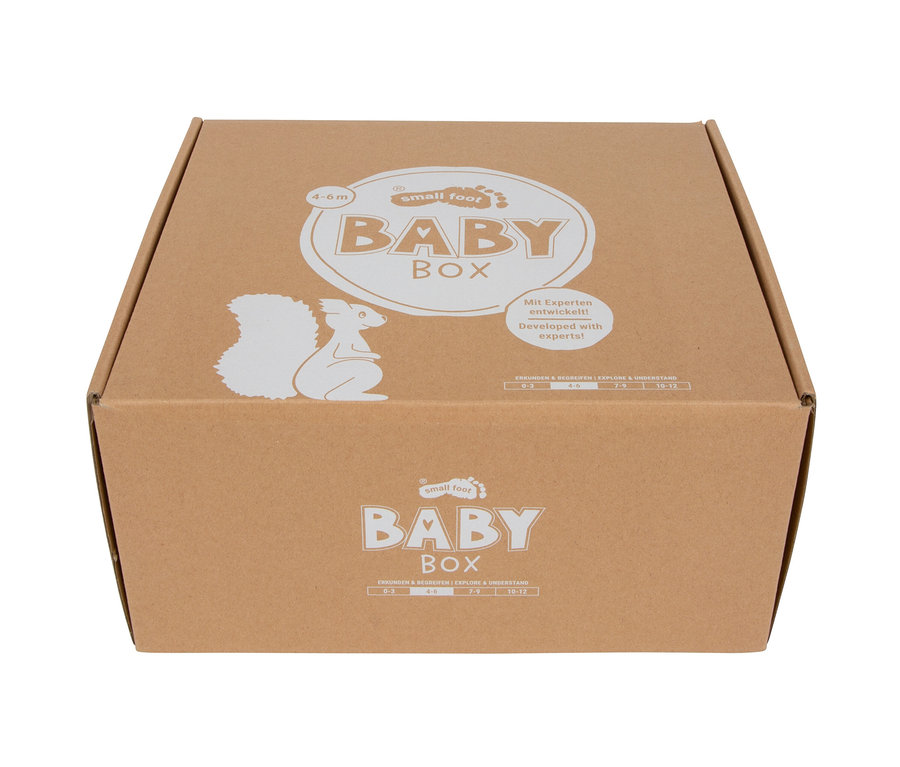 Brauner Karton mit weißem Aufdruck: „small foot BABY BOX“, Eichhörnchen-Silhouette, „Mit Experten entwickelt!“ und Altersangaben 0-12 Monate.