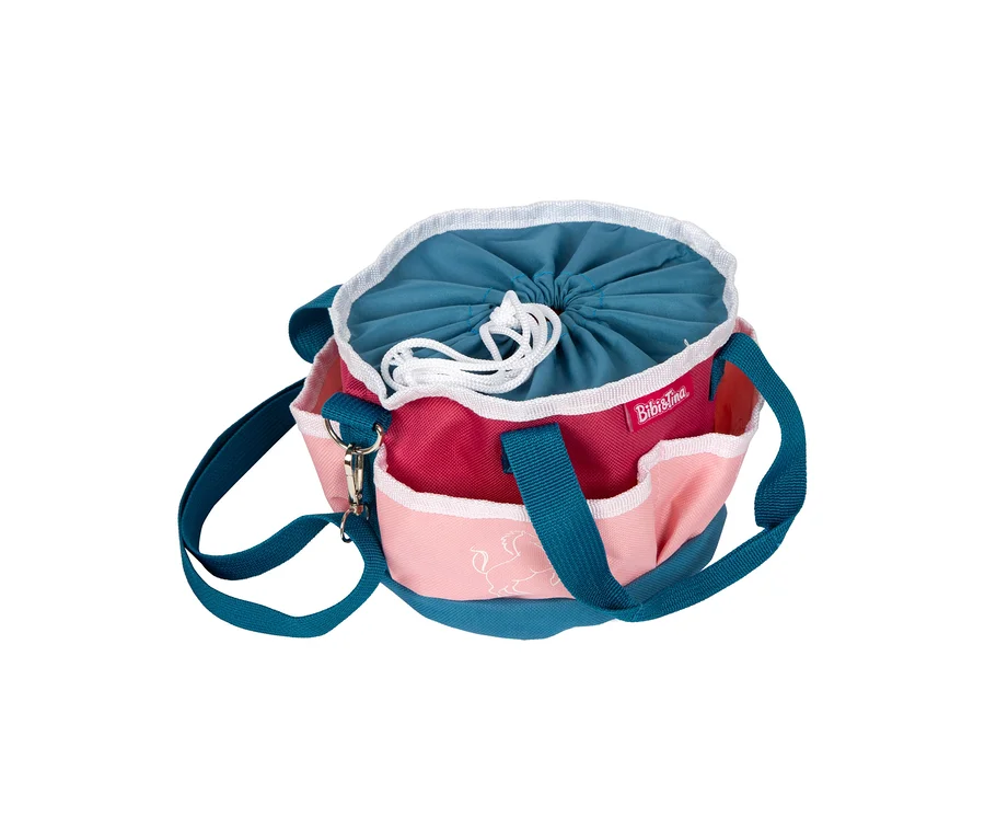 Eine bunte small foot Bibi & Tina Pferdepflege-Set Tasche mit türkisfarbenem Boden, fuchsiafarbenem Korpus, hellrosa Außentaschen und türkisfarbenem Kordelzug. Eine weiße Pferdeumrisszeichnung ist auf einer Tasche.