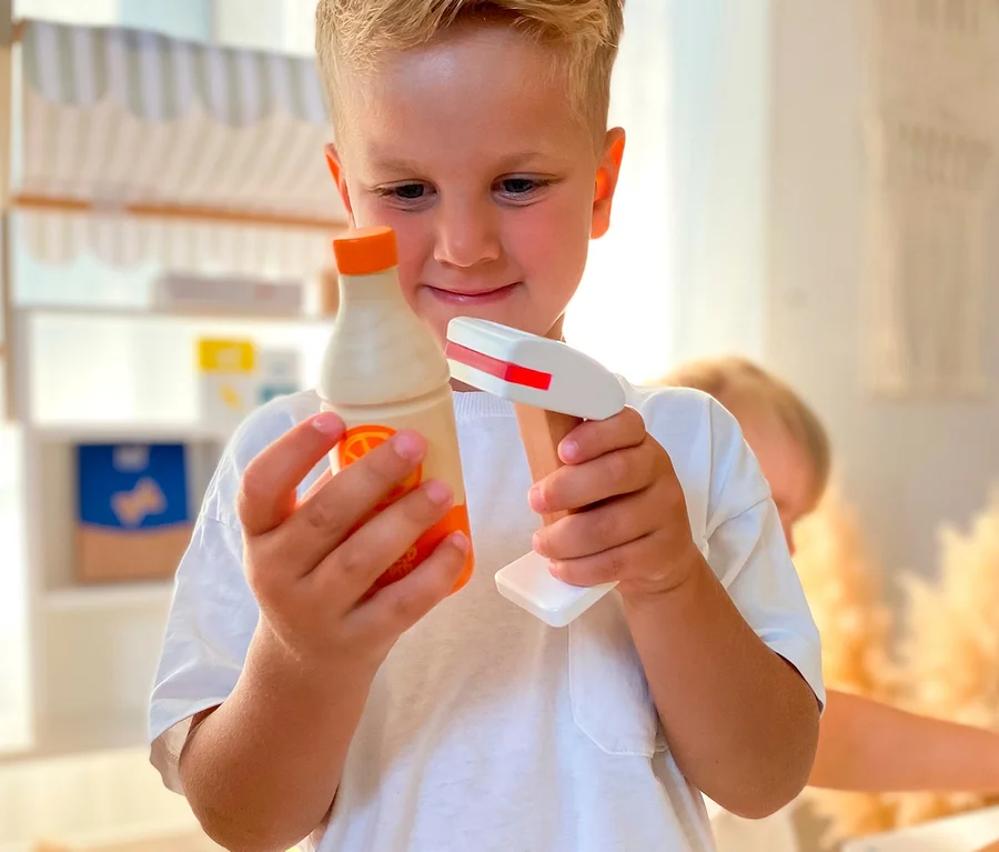 Junge hält hölzerne Spielzeugflasche und Scanner in der Nähe von small foot Kaufladen kompakt »fresh«.