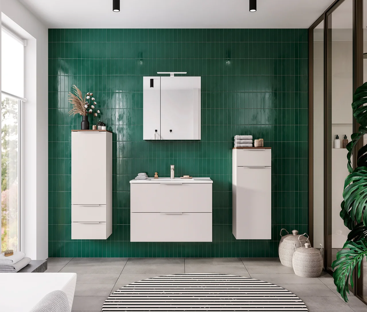 Modernes Badezimmer mit grünen Fliesen an der Wand. Ein weißer GW Waschtisch »Lasino« mit flachem Becken ist mittig platziert, darüber ein Spiegelschrank. Links und rechts hängen weiße Hochschränke mit Holzplatten. Ein runder schwarz-weiß gestreifter Teppich liegt auf dem grauen Boden.