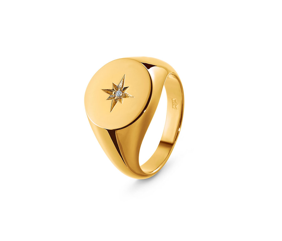 Detailaufnahme eines goldenen Rings mit einem Diamanten in der Mitte eines Sterns.