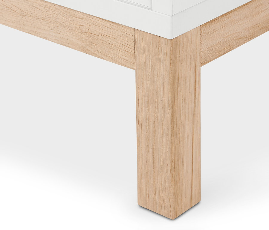 Detail einer Ecke eines weißen Bücherregals »Eklund« mit Türen, mit hölzernem Untergestell.