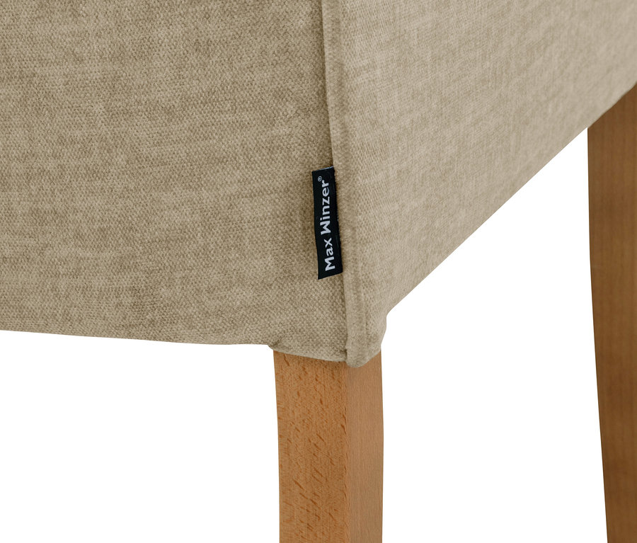 Detailansicht eines beigen Polsterstuhls »Leopold« mit Armlehne.