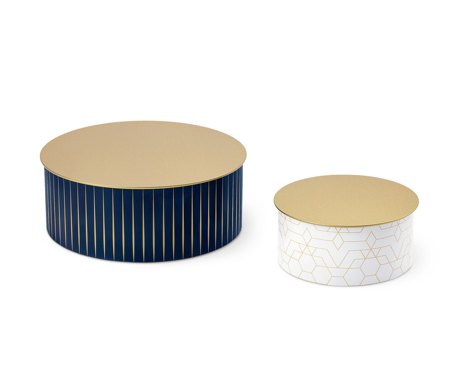 Zwei Keksdosen, eine dunkelblau mit goldenen Streifen, die andere weiß mit goldenen geometrischen Mustern.
