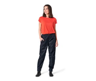 Eine Frau steht und trägt eine Unisex-Regenhose.