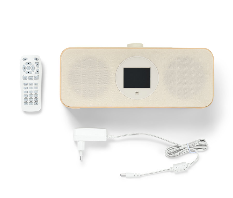 Ein hellbraunes WLAN-Internetradio mit Farbdisplay, eine Fernbedienung und ein Stromkabel liegen auf einem weißen Hintergrund.