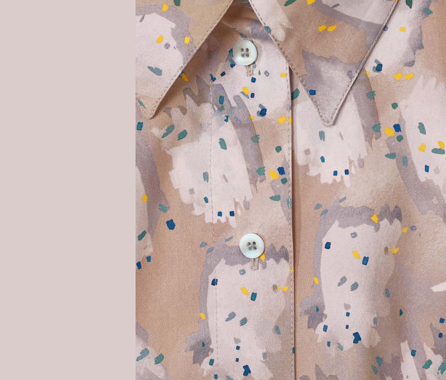 Detailansicht einer braunen NAH/STUDIO Longbluse aus Bio-Baumwolle mit Print, Kragen und Knöpfen.