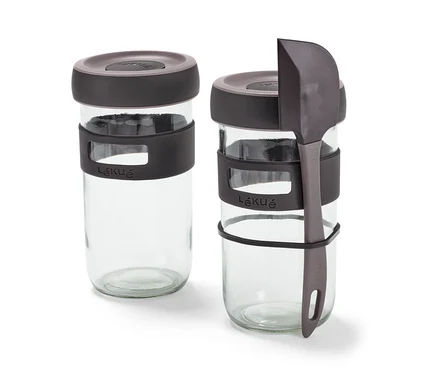 Zwei Gläser aus dem Sauerteig-Starter-Set und ein grauer Spatel.