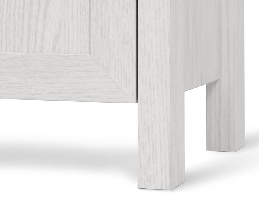 Detail einer weißen Kommode mit Tür und Schubladen.