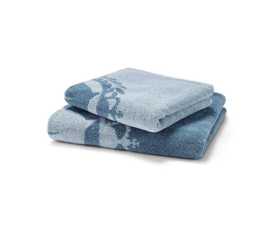 Ein Handtuch-Set in Hell- und Dunkelblau mit Baumdesign liegt übereinander.