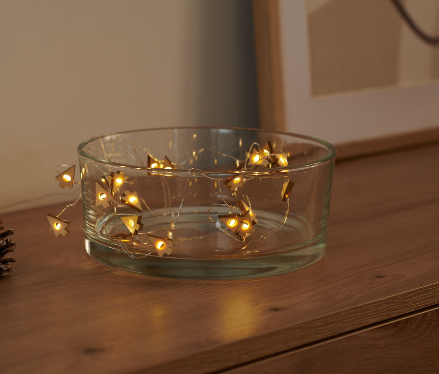 LED-Micro-Lichterkette »Tannen« liegt in einer transparenten Glasschale, daneben ein Tannenzapfen.