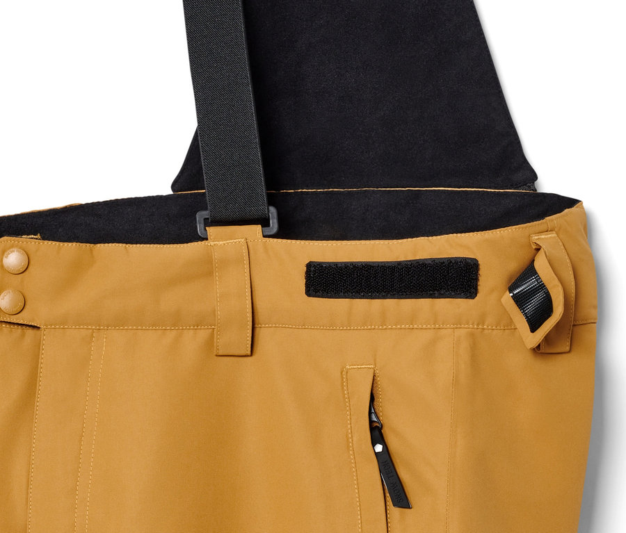 Detail einer Skihose in Camel mit schwarzen Hosenträgern.