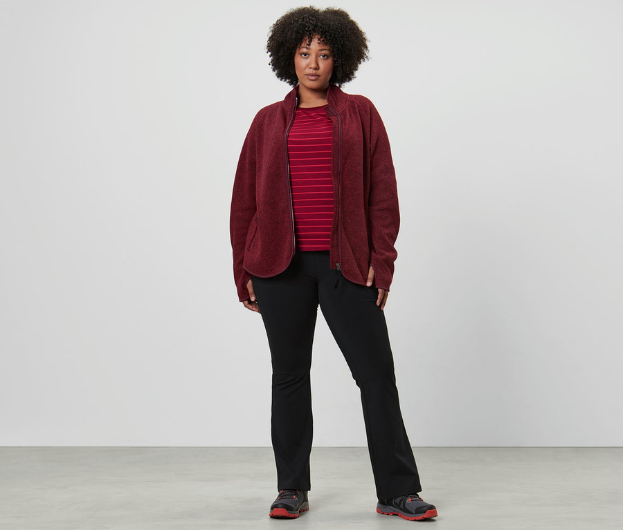 Frau trägt ein Langarm-Sportshirt, Thermo-Jazzpants und eine Strickfleece-Jacke, dunkelrot.