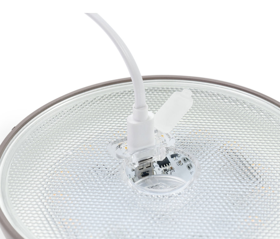 Detail einer LED-Akku-Tischleuchte, wobei ein Ladekabel in die Lampe eingesteckt ist.