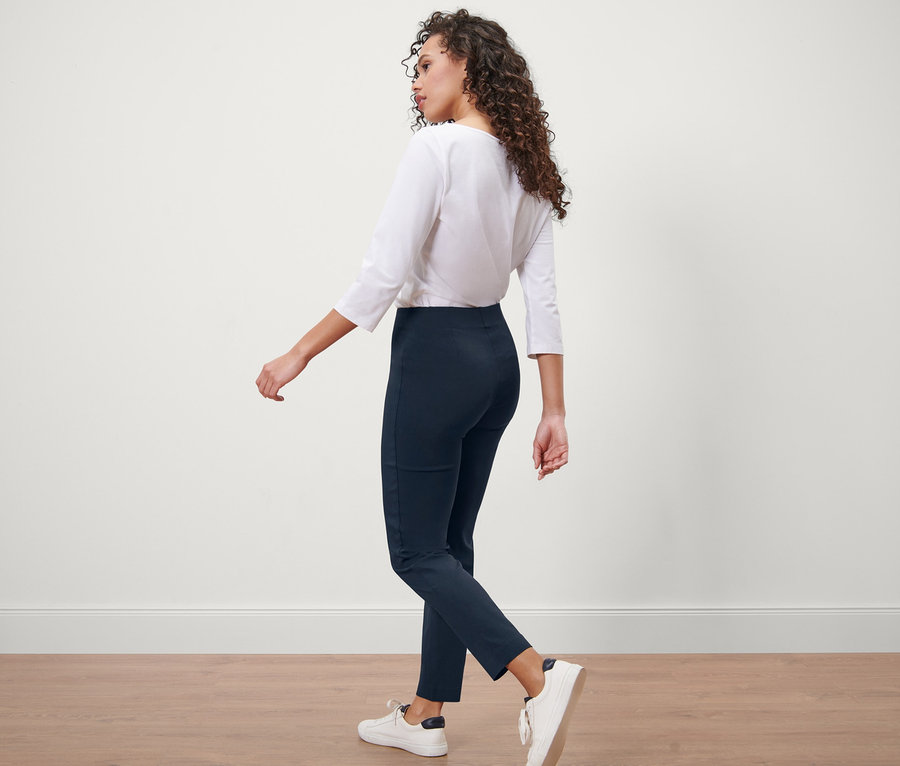 Frau geht in dunkelblauer Stretchhose.