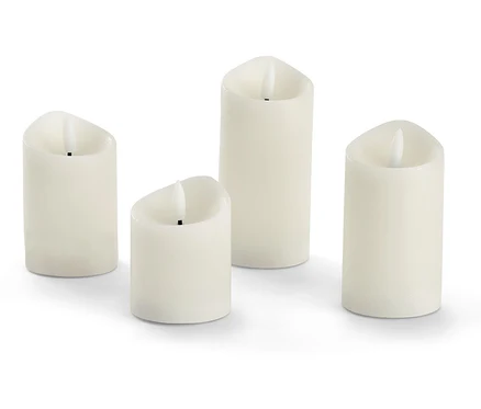 Vier creme LED-Echtwachskerzen.