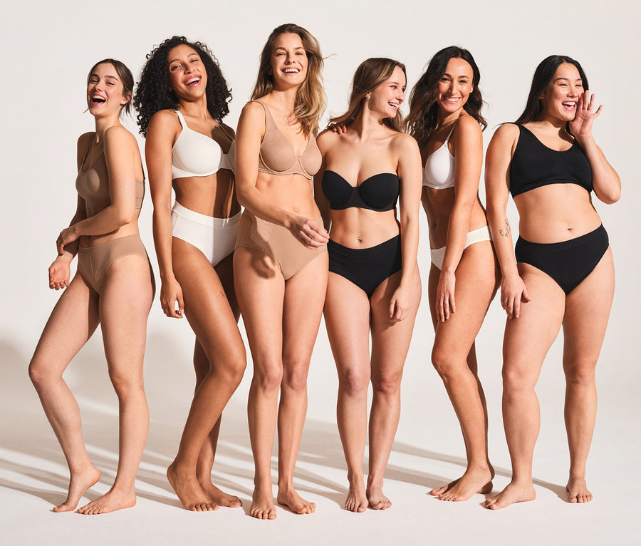 Sechs lächelnde Frauen in Unterwäsche stehen nebeneinander. Die Frauen tragen schwarze und weiße 2 SCHIESSER Bustiers mit Bio-Baumwolle.
