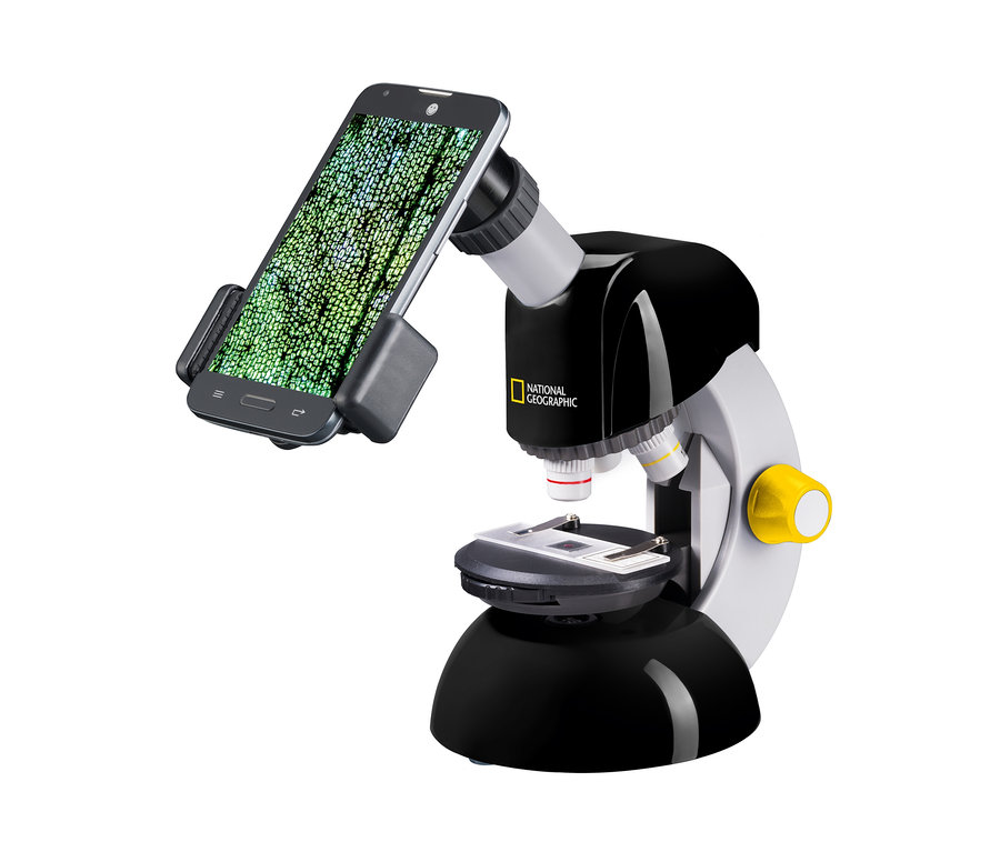 Nahaufnahme eines schwarzen und grauen Mikroskops mit Smartphone-Halterung und am Okular befestigtem Telefon. Zu sehen ist das NATIONAL GEOGRAPHIC Kompakt-Teleskop und Mikroskop mit Smartphonehalterung.
