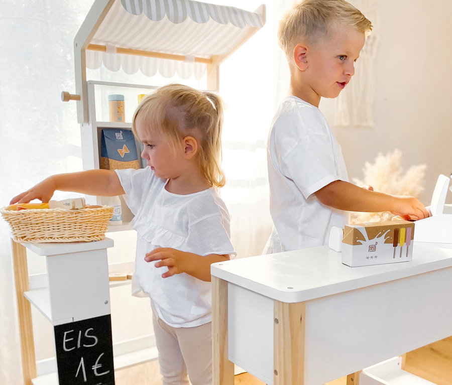 Zwei Kinder spielen mit einem Kaufmannsladen; Mädchen greift nach einem Korb, Junge steht an der Kasse; small foot Back-, Gefrier- und Kühlwaren-Set »fresh«