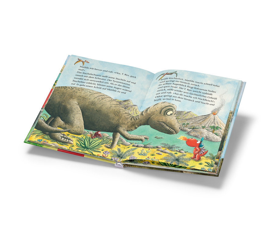 Aufgeschlagenes Buch zeigt eine Szene mit einem Dinosaurier und einem kleinen Drachen.