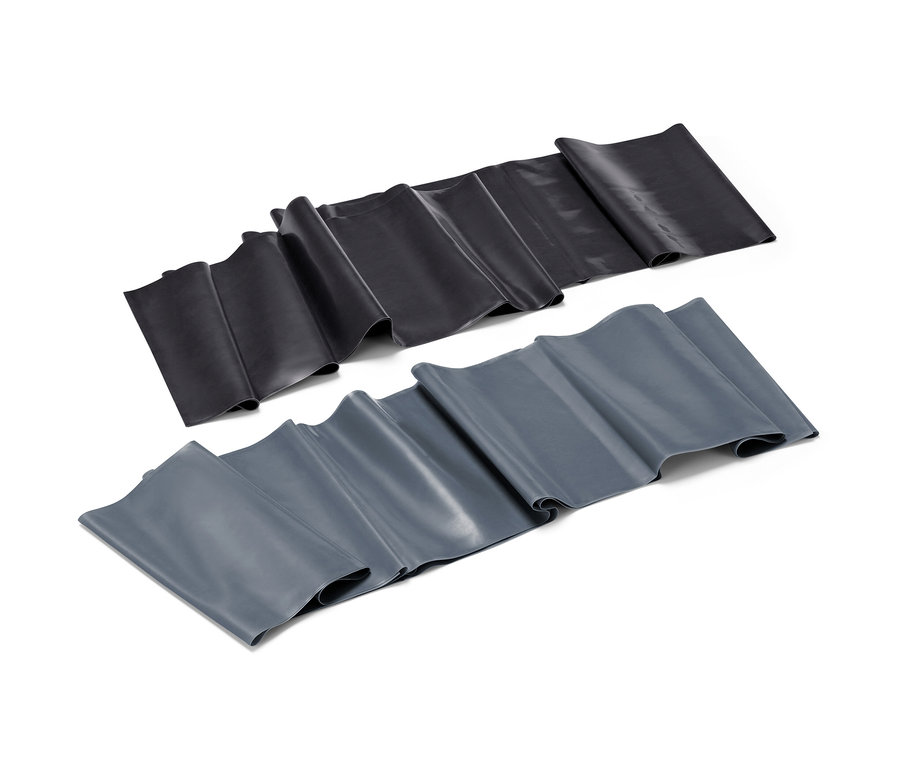 Zwei Fitnessbänder, eines schwarz, eines grau, liegen nebeneinander auf einem weißen Hintergrund.