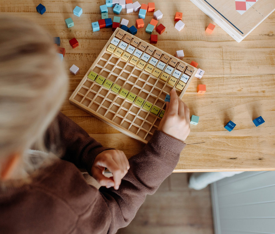 Kind spielt mit small foot Rechen-Set »Educate« auf einem Holztisch.