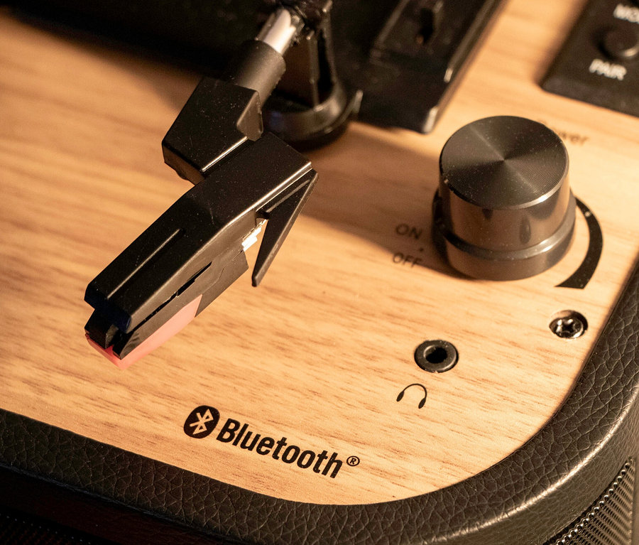 Detailaufnahme eines Plattenspielers mit Nadel, Bedienknopf und Bluetooth-Logo. Sichtbar ist ein Lenco Plattenspieler »TT-116« in Schwarz.