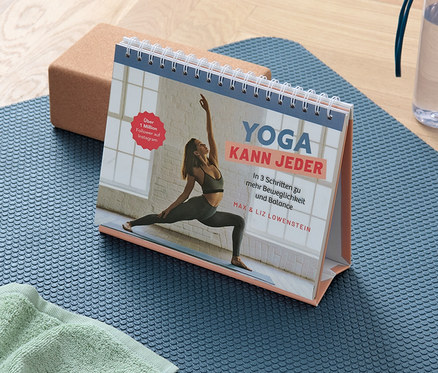 Eine blaue Yogamatte mit einem Handtuch, einem Block und dem Buch »Yoga kann jeder«.