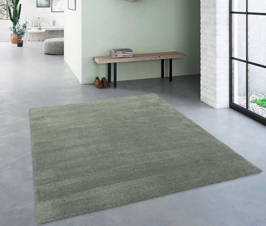 Eingangsbereich mit rundem Spiegel, Bank mit Büchern und grünem Teppich »Mellow«, ca. 60 x 115 cm.