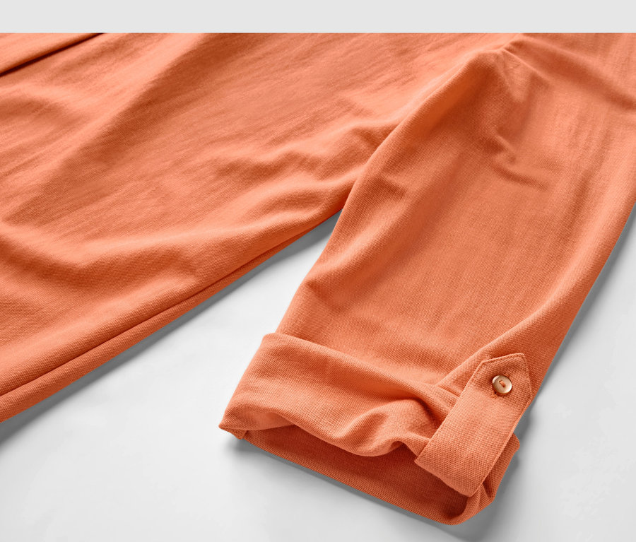 Detailansicht einer Piqué-Jerseybluse in Peach mit hochgekrempelten Ärmeln.