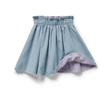 Blauer Kinder-Denim-Wenderock mit lila Futter mit weißen Punkten.