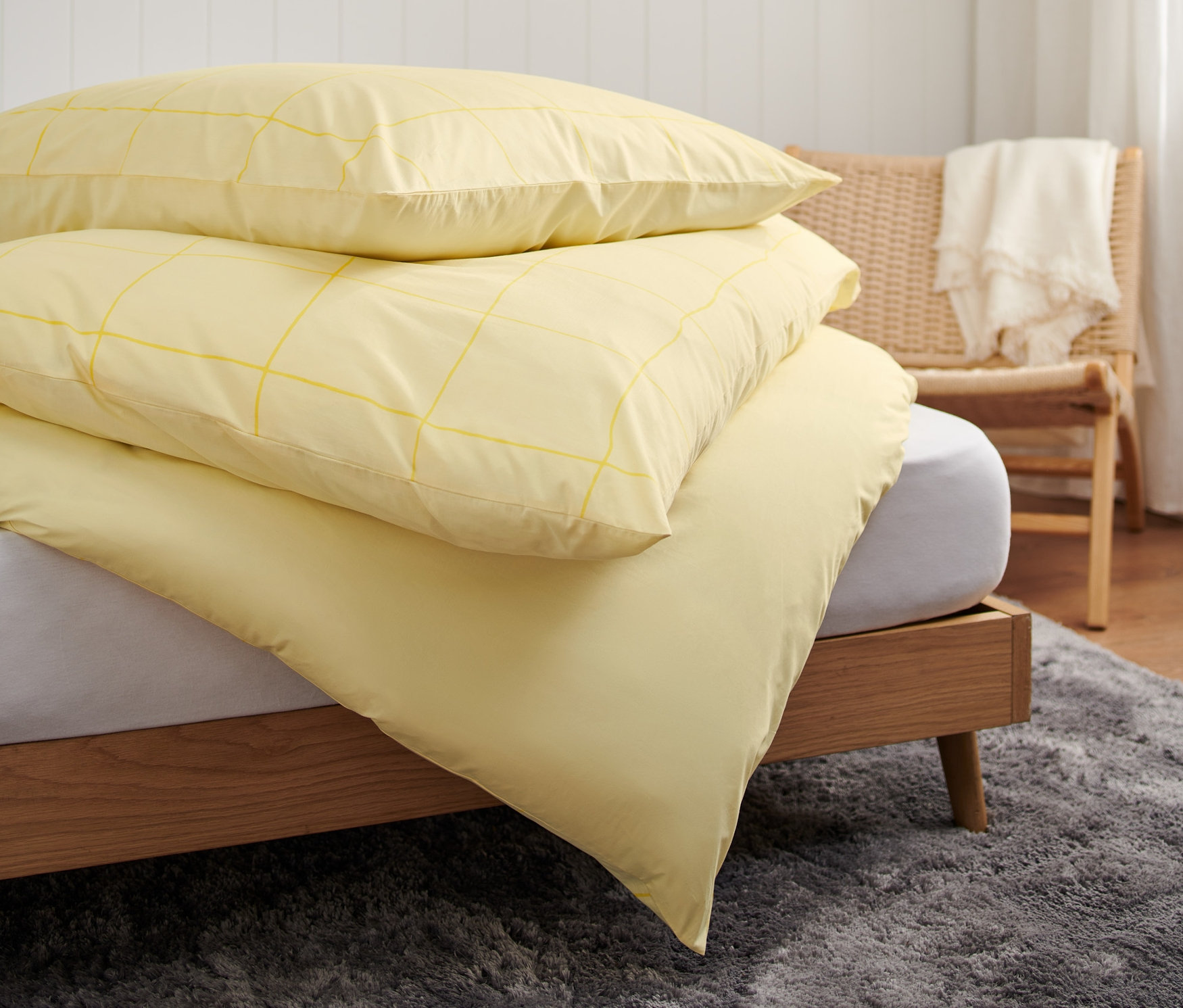 Ein Stapel Premium-Baumwoll-Bettwäsche in Normalgröße, Doppelgröße und Übergröße liegt auf einem Bett.